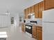 Bright kitchen features wooden cabinetry, white appliances, and a view into the living space at 150 Grove Creek Dr, Locust Grove, GA 30248