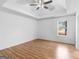 Spacious main bedroom with tray ceiling, light wood floors, and bright window at 150 Grove Creek Dr, Locust Grove, GA 30248