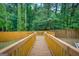 Wooden walkway leads to deck area surrounded by a lush, green backyard and privacy fence at 317 Lucan Way, Riverdale, GA 30274