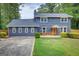 Charming two-story home featuring a gray exterior, well-manicured lawn, and bright orange front door at 317 Lucan Way, Riverdale, GA 30274