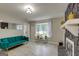 Living room featuring a teal couch, stone fireplace, and refinished gray floors at 317 Lucan Way, Riverdale, GA 30274