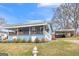Charming blue home featuring a metal roof, inviting front porch and a convenient carport at 1616 Park Ne St, Conyers, GA 30012