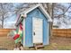Quaint blue storage shed with a white door and trim is accented by a decorative rooster sculpture at 1616 Park Ne St, Conyers, GA 30012