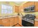 Well-lit kitchen featuring maple cabinets, granite counters, and stainless steel oven range at 3867 Summer Kitchen Way, Lilburn, GA 30047