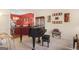 Home interior with a black piano in a carpeted room, with a red accent wall in background at 3867 Summer Kitchen Way, Lilburn, GA 30047