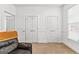 Bedroom features three white doors, neutral carpet, and a leather chair with a brown throw blanket at 155 Stayman Park, Fayetteville, GA 30215