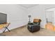 Neutral carpeted bedroom featuring a leather recliner, a floor lamp, and an open doorway at 155 Stayman Park, Fayetteville, GA 30215