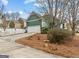 Charming green home featuring an attached two-car garage and a well-maintained front yard at 155 Stayman Park, Fayetteville, GA 30215