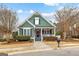 Charming green home featuring a welcoming front porch, manicured landscaping, and an American flag at 155 Stayman Park, Fayetteville, GA 30215