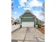 Side view of the house featuring an attached two-car garage and a white picket fence at 155 Stayman Park, Fayetteville, GA 30215