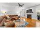 Inviting living room features a fireplace, hardwood floors, and comfortable leather sofa at 155 Stayman Park, Fayetteville, GA 30215