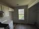 Functional kitchen space with overhead cabinets and a large window, showcasing storage at 133 Dove Lndg, Social Circle, GA 30025