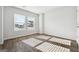 Bright bedroom featuring wood-look floors, white walls, and large windows at 106 Cowpen Ct, Walnut Grove, GA 30052