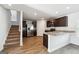 Open kitchen and staircase featuring stainless steel appliances, granite countertops, and wood-look floors at 106 Cowpen Ct, Walnut Grove, GA 30052