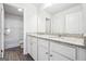 Bathroom featuring double vanities with granite countertops and white cabinets at 604 Clark Lake Estates Dr, Grayson, GA 30017