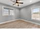 Cozy bedroom featuring wood floors, two bright windows, and a ceiling fan at 10 Last St, Moreland, GA 30259