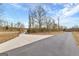 Long, paved driveway leading to a gated property entrance, lined with a wooden fence and mature trees at 10 Last St, Moreland, GA 30259