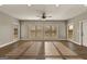 Bright living room featuring hardwood floors, neutral walls, a ceiling fan, and large windows with views of the outdoors at 10 Last St, Moreland, GA 30259