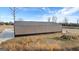 Large modern outbuilding on a sprawling property, complemented by a long paved driveway and natural landscape at 10 Last St, Moreland, GA 30259