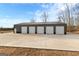 Large, modern outbuilding with multiple garage doors and ample parking space, set on a spacious lot at 10 Last St, Moreland, GA 30259
