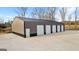 Modern outbuilding with four garage doors, featuring ample parking space and a side entry door, set on a lot at 10 Last St, Moreland, GA 30259
