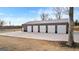 Spacious, modern outbuilding featuring multiple garage doors and a concrete apron, bordered by a natural landscape at 10 Last St, Moreland, GA 30259