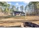 Spacious backyard featuring a covered patio and bordered by mature trees, creating a serene outdoor setting at 1012 Matthews Way, Mcdonough, GA 30252