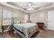A bedroom with a large upholstered bed frame, tray ceiling, and lots of natural light at 1012 Matthews Way, Mcdonough, GA 30252