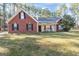 Charming red brick home featuring black shutters, a well-manicured lawn, and a cozy front porch with rocking chairs at 1012 Matthews Way, Mcdonough, GA 30252