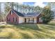 Charming red brick home featuring black shutters, a well-manicured lawn, and a cozy front porch with rocking chairs at 1012 Matthews Way, Mcdonough, GA 30252