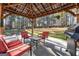 Inviting covered patio with outdoor seating and grill, perfect for entertaining in a wooded backyard at 1012 Matthews Way, Mcdonough, GA 30252