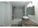 A modern bathroom featuring a tiled shower and tub combo, decorative mirror and custom vanity at 1269 Snapping Shoals Rd, Mcdonough, GA 30252