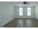 Bright, empty bedroom with two large windows offering plenty of natural light, plus modern ceiling fan and beautiful floors at 1269 Snapping Shoals Rd, Mcdonough, GA 30252