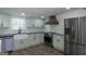 Updated kitchen features stainless steel appliances, farmhouse sink, and custom range hood at 1269 Snapping Shoals Rd, Mcdonough, GA 30252