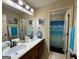 Bathroom featuring double sink vanity, large mirror, and separate shower with cloud curtain at 306 Oakwind Way, Canton, GA 30114