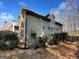 Exterior view shows home with stone and siding, set in a treed lot, capturing a blend of charm and nature at 306 Oakwind Way, Canton, GA 30114