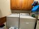 A laundry room with wood cabinets above a washer and dryer at 306 Oakwind Way, Canton, GA 30114