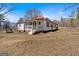 Charming single-story home with a red roof, white siding, and welcoming porch, offering warmth and curb appeal at 5700 Mount Zion Rd, Waco, GA 30182