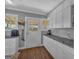 Well-lit kitchen featuring white cabinets, granite countertops, and wood-look flooring at 5700 Mount Zion Rd, Waco, GA 30182