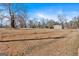 Vast grassy yard offering ample space, complemented by the view of a house and detached garages in the distance at 5700 Mount Zion Rd, Waco, GA 30182