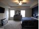 Spacious bedroom with a large bed, ceiling fan, and plenty of natural light at 620 Calvo Run, Mcdonough, GA 30253