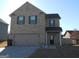Two-story brick home featuring an attached garage and dark green shutters at 620 Calvo Run, Mcdonough, GA 30253