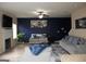 Cozy living room with dark blue accent wall, ceiling fan, and fireplace at 620 Calvo Run, Mcdonough, GA 30253