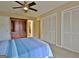 Bedroom boasts neutral walls, ceiling fan, and carpet flooring with closet and armoire at 26 Cobblestone Creek, Peachtree City, GA 30269