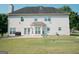 Back exterior with a large yard, outdoor patio, and well-maintained lawn at 424 Norman Ct, Hampton, GA 30228