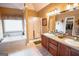 Bright bathroom featuring a soaking tub, glass shower, dual vanities, and an open closet at 424 Norman Ct, Hampton, GA 30228