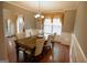 Formal dining room with a wood table, six chairs, hardwood floors, and decorative lighting at 424 Norman Ct, Hampton, GA 30228
