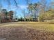 Expansive backyard with ample green space, mature trees, and a fenced perimeter at 407 Holly Grove Church Rd, Peachtree City, GA 30269