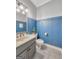 Powder room with blue accent wall, modern fixtures and under-sink cabinet space at 407 Holly Grove Church Rd, Peachtree City, GA 30269