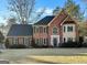 Charming two-story brick home featuring a well-manicured lawn and a classic architectural design at 407 Holly Grove Church Rd, Peachtree City, GA 30269